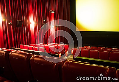 Empty cinema with blank screen and rows of red seats Stock Photo