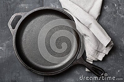 Empty, clean black cast iron pan or dutch oven top view from above on black table with towel Stock Photo