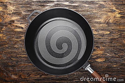 empty clean cast iron skillet on a wooden background. Stock Photo