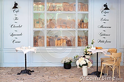 Empty coffee and restaurant terrace with tables and chairs in French style. Freshly baked pastries and bread in bakery showcase. S Stock Photo