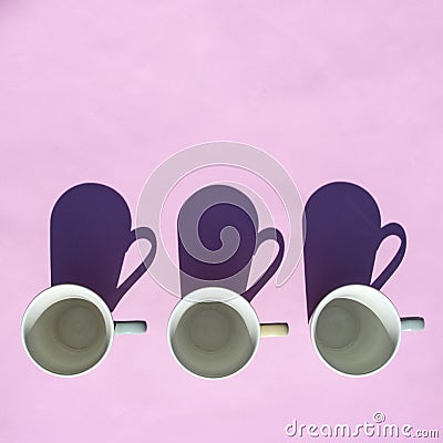 Empty coffee and tea cups stand in row on pink background in sunlight with shadows. Top view, flat lay. Minimal style. Art design Stock Photo