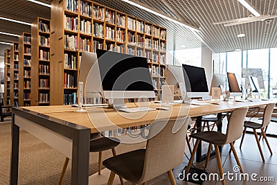 Empty computer room in the school library. Modern computers stand on a wooden table. Stock Photo