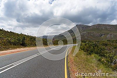 Empty countryside road with warning road sign of sharp road bend ahead Stock Photo