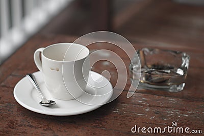 Empty cup of coffee and ashtray. Stock Photo