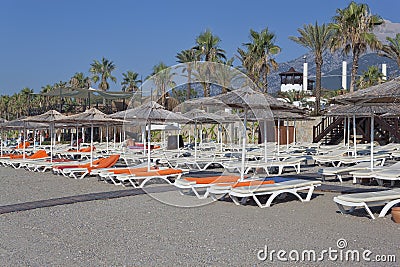 Empty deckchairs with mattresses and towels and umbrellas with a Stock Photo