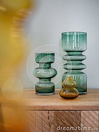 Empty decorative vases from transparent glass on wooden cupboard with blured foreground. Interior decoration Stock Photo