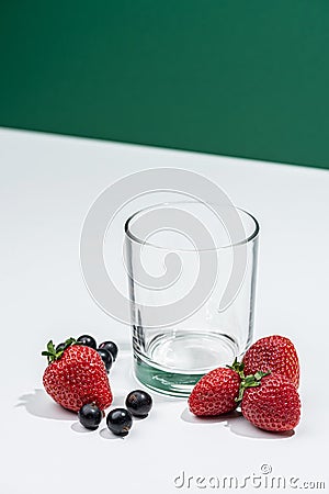 Empty even glass with fresh strawberries nearby Stock Photo