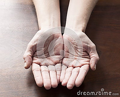 Empty female hands holding something round to offe Stock Photo