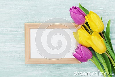 Empty frame and tulip flowers on rustic table for March 8, International Womens day, Birthday or Mothers day Stock Photo