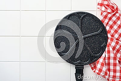 Empty frying pan black, skillet with stone nonstick coating for baking pancakes in shape of breakfast hearts and ingredients on gr Stock Photo