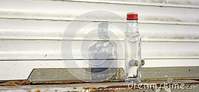 Empty glass bottle throw out on poor dirty street in post USSR Russian outdoor depression environment alcoholism problem concept Stock Photo