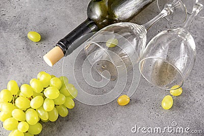 2 empty glasses, bottle, bunch of green grapes on a gray Stock Photo