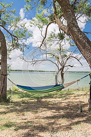 Lakeside hammock hanging between trees sunny day Stock Photo
