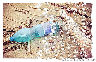 Empty green plastic bottle abandoned on the beach - concept image in jigsaw puzzle shape Stock Photo