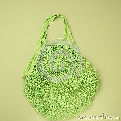 Empty green reusable string bag woven from thread on a green background Stock Photo