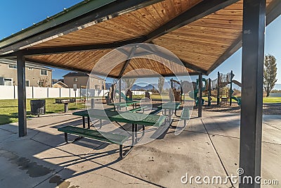 Empty green tables and benches in an urban park Stock Photo