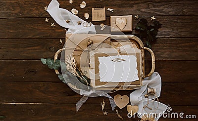 Empty greeting card with kraft envelope and gold decorations on wooden background. Wedding concept. Stock Photo