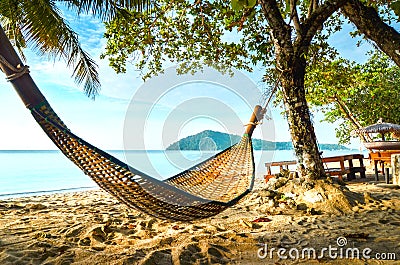 Empty hammock between palm trees on tropical beach Stock Photo