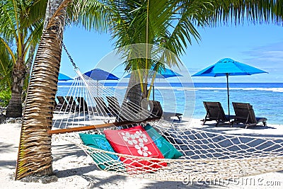 Empty hammock between palm trees on tropical beach Stock Photo