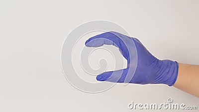 Empty Hand holding or catch nothing guesture on white background.Hand wear violet or purple latex glove Stock Photo
