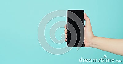 Empty Hand holding mobile phone guesture on green and blue or mint background Stock Photo