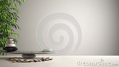 Empty interior design feng shui concept zen idea, white table or shelf with pebble balance and green bamboo, over white blank back Stock Photo