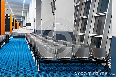 Empty international airport building during pandemic. Empty seat rows at airport lounge Stock Photo