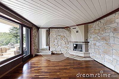 Empty living room with parquet, fireplace, windows and rock on the walls Stock Photo