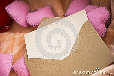 Empty love letter over toy heart shapes. Invitation for Valentines Day concept. Stock Photo