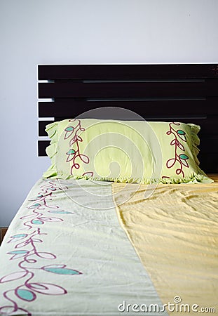 Empty and messy bed with green pillow, Stock Photo
