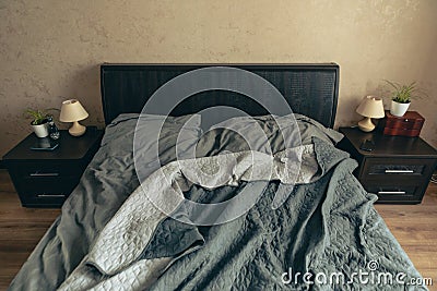 empty messy bed with grey sheets Stock Photo
