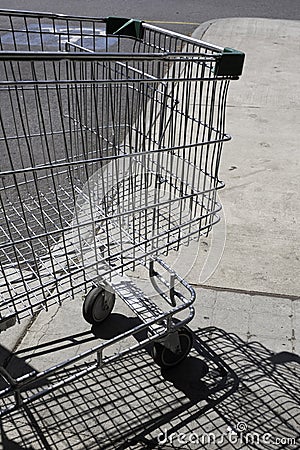 Empty metal shopping cart with shadow outside a supermarket Stock Photo