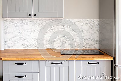 Empty modern minimal grey color kitchen, solid natural wood butcher block counter. Stock Photo