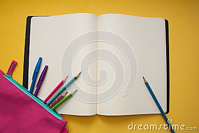 Empty notebook and colorful pencils on yellow background Stock Photo