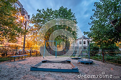 Empty obsolete abandoned children's playground in the evening Stock Photo