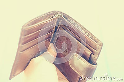Empty open brown purse in one hand. Stock Photo
