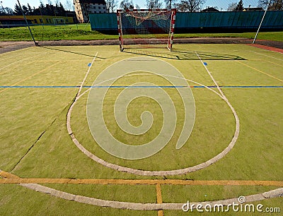 Empty outdoor handball playground, plastic hairy green surface on ground and white blue bounds lines. Stock Photo