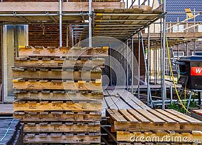 Empty pallets with scaffolding in the background, construction site in Rucphen, The Netherlands, 6 may, 2022 Editorial Stock Photo