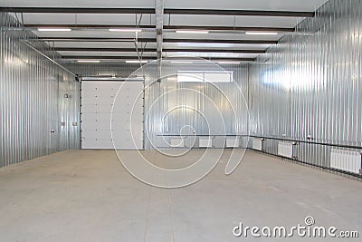 Empty parking garage, warehouse interior with large white gates and windows inside Stock Photo