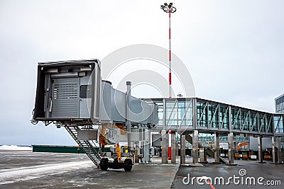 Empty passenger air bridge at the winter airport apron Stock Photo
