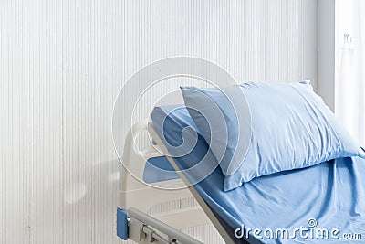 Empty patient`s bed scene with white wooden paint background in natural light scene / hospital and insurance concept / ward room Stock Photo