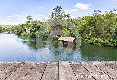 Old wooden balcony terrace floor with bamboo raft hut floating in river Stock Photo