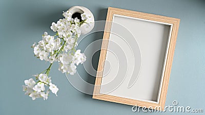 Photo frame and flowers in vases on blue pastes background. Stock Photo