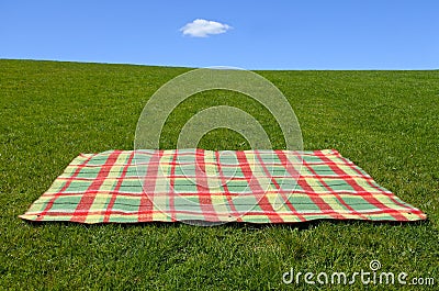 An empty picnic blanket on green grass Stock Photo