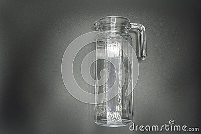 Empty pitcher, glass jug isolated on gray background Stock Photo