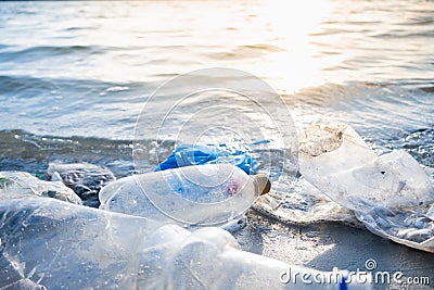 Empty plastic bottles on the beach, seashore and water pollution concept. Stock Photo