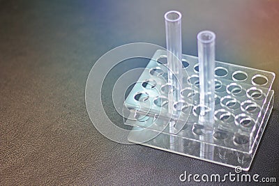 Empty plastic test tube Two tubes on the holder Black leather tabletop background.Glass test tube in science laboratory, black Stock Photo