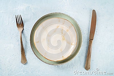 An empty plate with a gold rim, with silverware, overhead flat lay shot Stock Photo