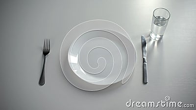 Empty plate served on table, glass with water, no money for food, poverty Stock Photo