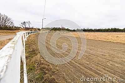 Empty race track for racing horses, sand track and white fence Stock Photo